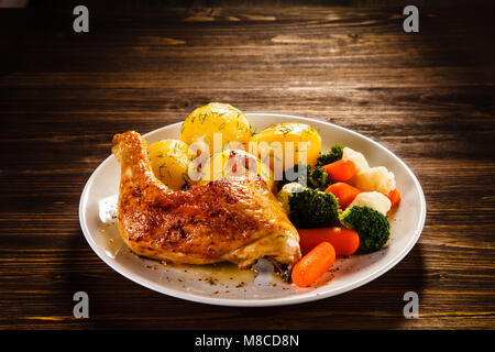 Roast chicken leg with boiled potatoes and vegetables Stock Photo
