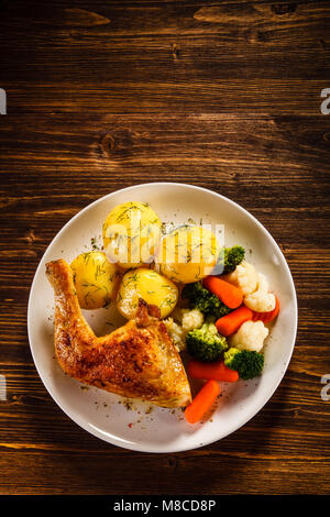 Roast chicken leg with boiled potatoes and vegetables Stock Photo