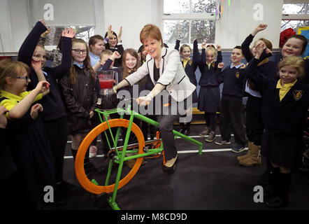 First Minister Nicola Sturgeon tries out a smoothie-making bike during in a bikeability repair workshop with pupils at Wellshot Primary School in Glasgow as she launches the latest round of Climate Challenge Funding which includes the 1,000th recipient, the Bike for Good project at the school. Stock Photo