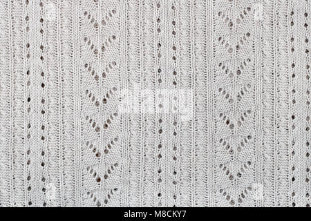 The female sweater is knitted from white cotton threads. A pattern in the form of triangles, holes and lines.Mass production Stock Photo