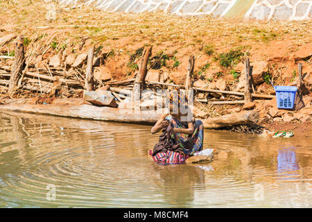 Elderly Burmese woman washing clothes laundry in Inle Lake, near Indein Village, Shan State, Myanmar (Burma), Asia in February - washday wash day Stock Photo