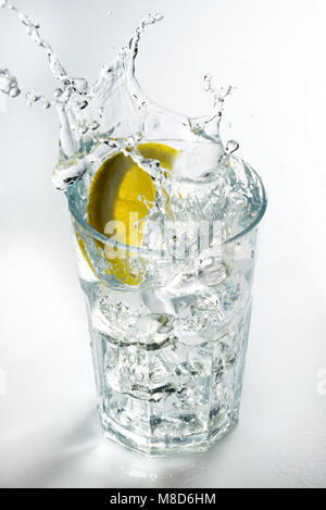 Lemon splashing on a glass against a white background Stock Photo