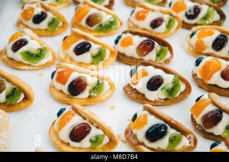 cakes with pieces of fruit cream are on a baking tray and ready to eat. Stock Photo