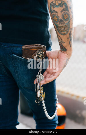 Rear view of man with keys in back pocket and skull tattoo, cropped Stock Photo