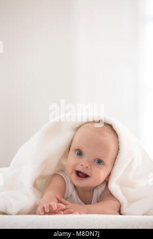 Portrait of cute baby boy wrapped in white towel Stock Photo