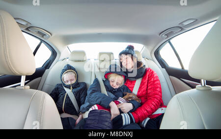 Mother and children sleeping in car Stock Photo