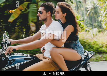 Young couple riding on motorcycle on rural road, Krabi, Thailand Stock Photo