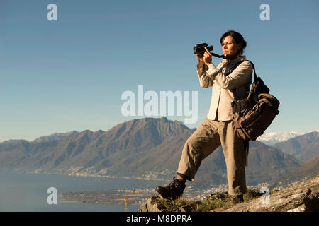 Woman Takes Pictures From Mountain Overlook in Ticino, Switzerland Stock Photo