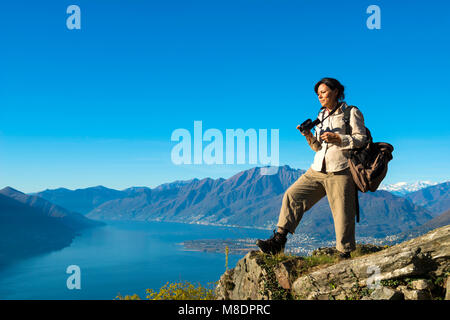 Woman Takes Pictures From Mountain Overlook in Ticino, Switzerland Stock Photo