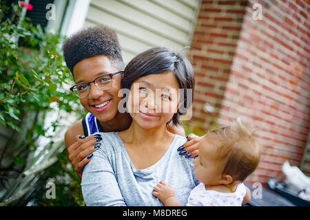 Portrait of teenage boy with mid adult woman and baby daughter Stock Photo