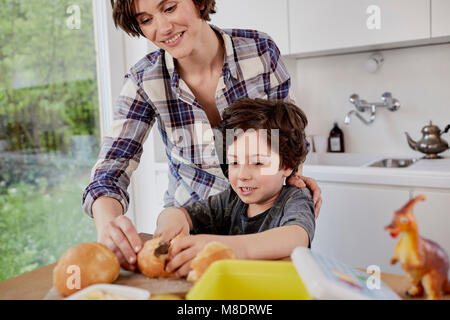 Mother and son preparing food in kitchen Stock Photo