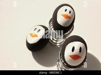 Penguin Easter Eggs made by hand on metal egg cup white background Stock Photo