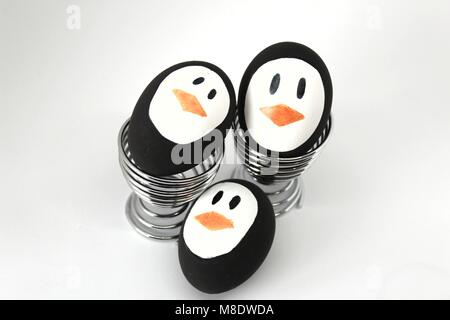 Penguin Easter Eggs made by hand on metal egg cup white background Stock Photo