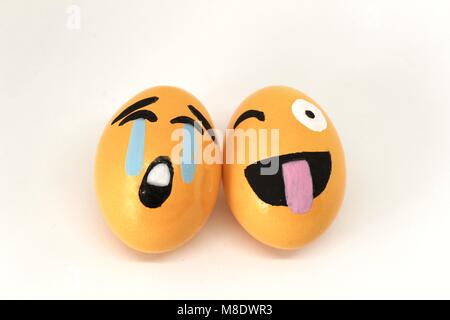 Smiling and crying Emoticons Easter Eggs and white background. Stock Photo