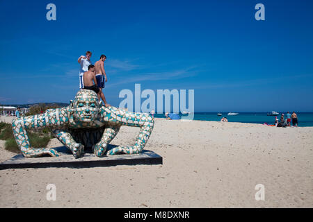 Young people standing on a Rabarama sculpture at Pampelonne beach, popular beach at Saint-Tropez, french riviera, South France, Cote d'Azur, France Stock Photo
