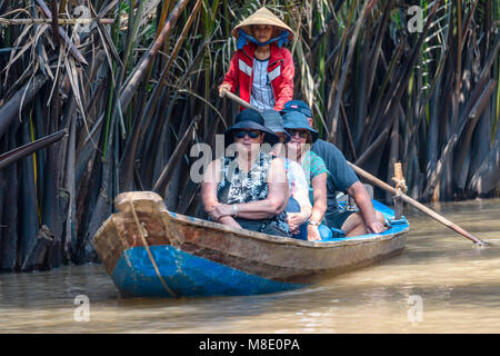 Tourists are taken down a jungle river in rowing boats on the Meekong Delta, Vietnam Stock Photo