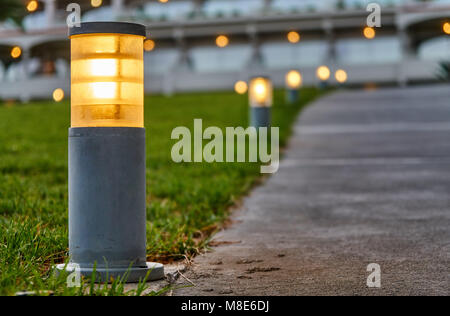 Street lights located along the footpath on the grass in hotel territory Stock Photo