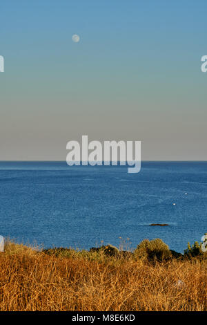 Moon over the calm sea on a warm evening Stock Photo