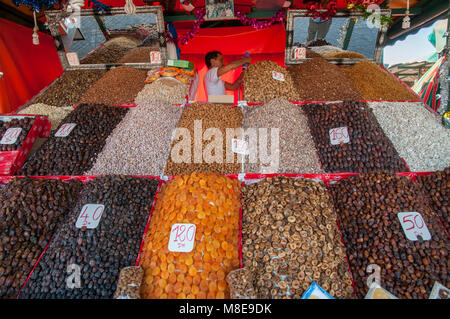 Vendor with his goods of dried fruits and nuts at one of the many stalls in Jemaa el-Fna square in Marrakesh, Morocco. Stock Photo