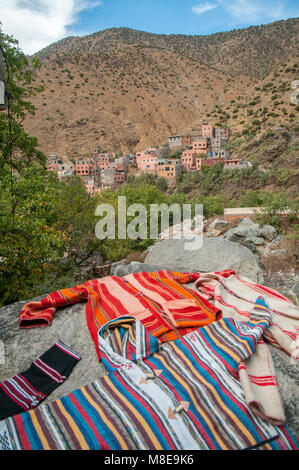 Colourful locally hand-crafted clothes on display near the village of Setti-Fatma in the Atlas mountains, Morocco.