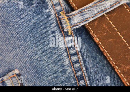 Pair of jeans with a battered leather belt, close-up Stock Photo