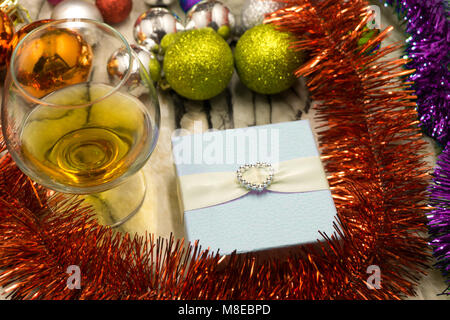 Christmas Gift with Gold Bow and Colorful Balls over red Stock Photo