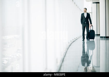 Business man at international airport moving to terminal gate for airplane travel trip. Stock Photo