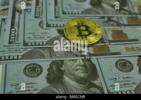 Gold and copper Bitcoin coins and silver litecoin and 100 dollar banknote on computer mother board - close up shot.Digital currency physical metal Bit Stock Photo
