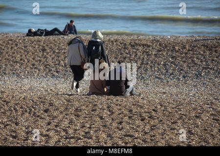 Brighton,UK,16th March 2018,People enjoy the warm and sunny weather and sit on the beach at Brighton.credit Keith Larby/Alamy Live News Stock Photo