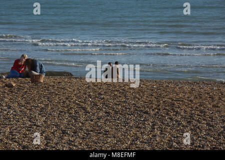 Brighton,UK,16th March 2018,People enjoy the warm and sunny weather and sit on the beach at Brighton.credit Keith Larby/Alamy Live News Stock Photo