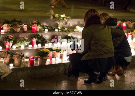 16 March 2018, Germany, Flensburg: Two young women lay down flowers and candles on the steps before the altar during the memorial service for a 17-year-old in St. Nicholas' Church. The police is investigating against an 18-year-old suspect, who remains in custody. Photo: Malte Christians/dpa Stock Photo