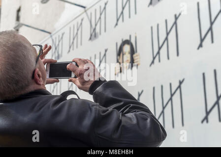 New York, NY, USA. 16th March, 2018. - Photographers and art lovers flock to Houston Street to view one of two new pieces by Street Artist, Banksy. Banksy unveiled the work Thursday which highlights the case of a Turkish artist,  Zehra Doğan was reportedly imprisoned in 2017 for her painting of a damaged Turkish city.  Credit: Stacy Walsh Rosenstock/Alamy Live News Stock Photo