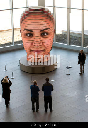 Columbus, Ohio, USA. 16th Mar, 2018. ''As We Are, '' a sculpture by Columbus College of Art & Design professor Matthew Mohr, displays a series of portraits of people's faces. After a photograph is made inside the back of the sculpture by a bank of digital camera, the ''ultimate selfie'' is then superimposed onto a 14-foot blank ''head'' by 850,000 LED lights. Thousands of these images are now in the archived memory and in rotation for viewing by visitors to the Greater Columbus Convention Center. Credit: Brian Cahn/ZUMA Wire/Alamy Live News Stock Photo