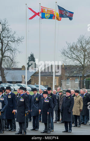 London, UK, 17 Mar 2018. Veterans in bowlers join the parade and wait under the Royal Banner, The regimental flag and the Saint Patrick's Saltire - The Duke of Cambridge, Colonel of the Irish Guards, accompanied by The Duchess of Cambridge, visited the 1st Battalion Irish Guards at their St. Patrick's Day Parade. 350 soldiers marched onto the Parade Square at Cavalry Barracks led by their mascot, the Irish Wolfhound Domhnall. Her Royal Highness presented the shamrock to Officers and Warrant Officers, who in turn issued it along the ranks. The parade concluded with a march-past during which His Stock Photo