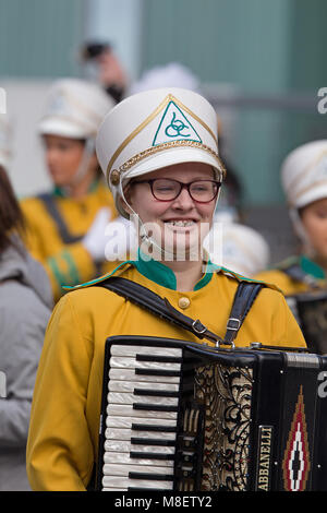 Liverpool, UK. 17th March. Young girl in glasses playing the accordion at the St Patrick's Day parade in Liverpool City Center. Credit; Ken Biggs/Alamy Live News Stock Photo