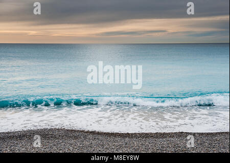 A view of the Ligurian Sea from the promenade in Nice in the south of France. Taken in winter with a dramatic sky and relatively calm water. Stock Photo