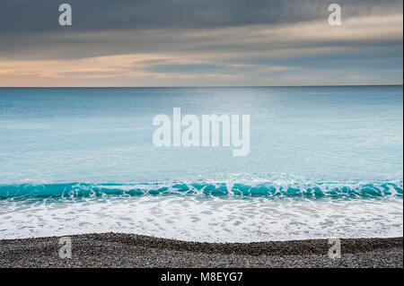 A view of the Ligurian Sea from the promenade in Nice in the south of France. Taken in winter with a dramatic sky and relatively calm water. Stock Photo