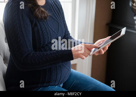 Pregnant woman using digital tablet Stock Photo