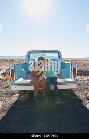 USA, Arizona, Mother with son (6-7) sitting on tailgate of pick-up truck Stock Photo