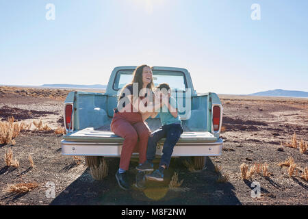 USA, Arizona, Mother with son (6-7) sitting on tailgate of pick-up truck Stock Photo