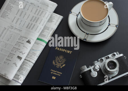 Passport, coffee, old camera and newspapers lying on table Stock Photo