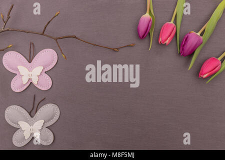 Spring flowers on a slate plate with butterflies Stock Photo