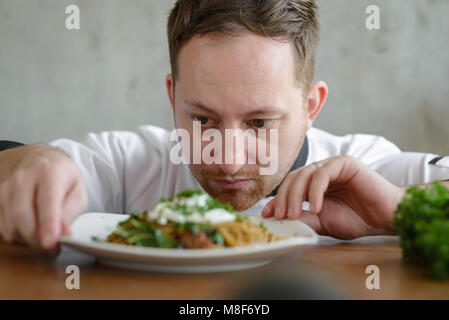 Chef in in a restaurant or hotel kitchen, checking up his food and ready for service to the customer Stock Photo