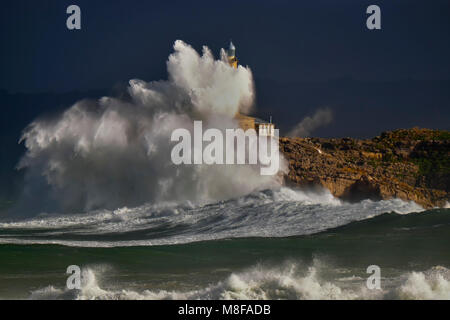 The Mouro island lighthouse during a storm. Big waves, more of 10 meters. Santander, Spain. Stock Photo