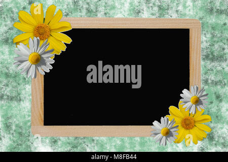 blackboard with black surface on green background and frame with daisies Stock Photo