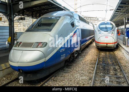 A TGV high speed train from french company SNCF next to an ICE bullet train from german company Deutsche Bahn in Paris Gare de l'Est train station.