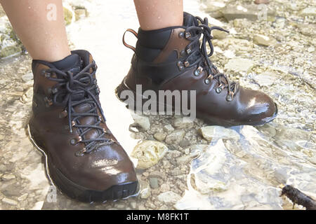 Young Woman Walking on the River with Hiking Boots Stock Photo