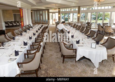 Woman setting wine glasses in place for formal wine club dinner, Naples, Florida, USA Stock Photo