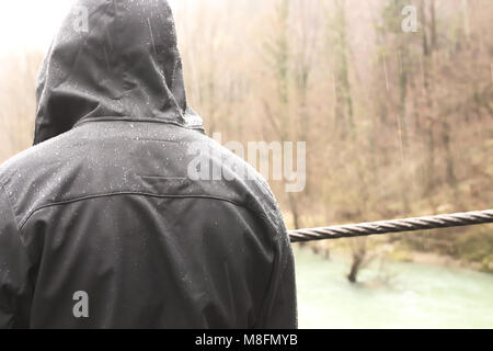 Rear view of Young Man in Wet Jacket when its Raining Stock Photo