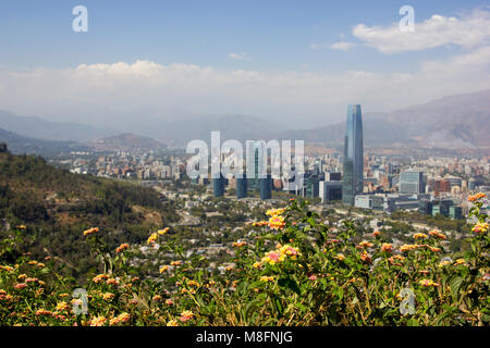 With lantana flowers in the foreground, the city of Santiago can be seen in the distance from Cerro San Cristobal. Stock Photo
